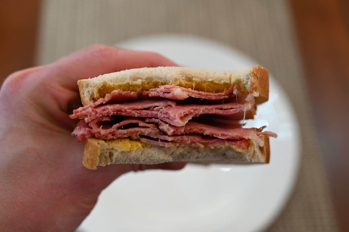 Close up image of a Costco Schwartz's Smoked Meat sandwich with a bite taken out of it. 