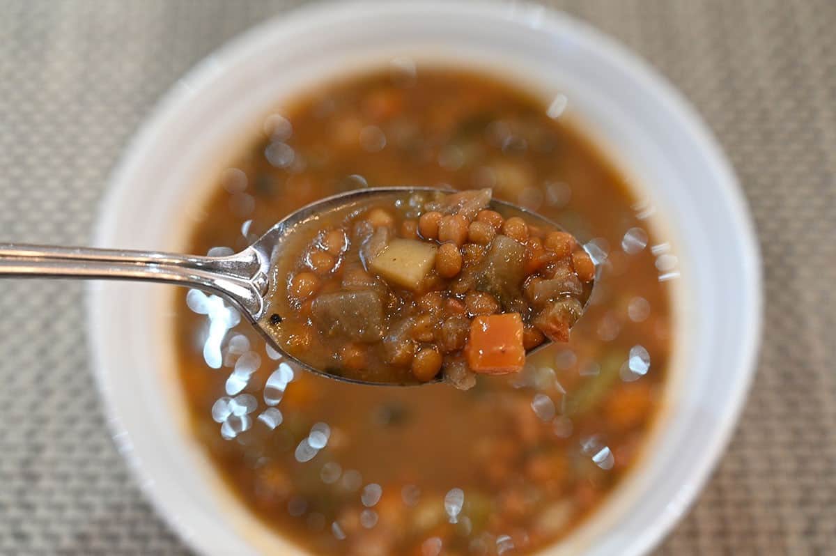 Close-up image of the Costco Lentil Soup on a soup with the bowl of soup in the background. 