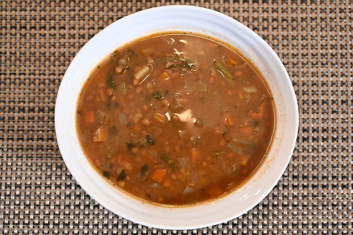 Lentil soup heated and served in a white bowl, top down image. 