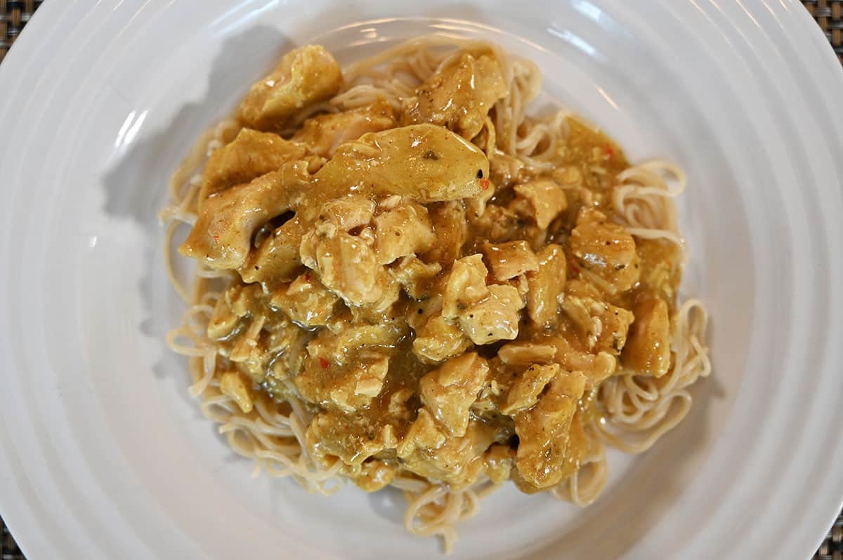 Costco Stoney Creek Thai Coconut Chicken heated and served on a white plate on a bed of noodles. 