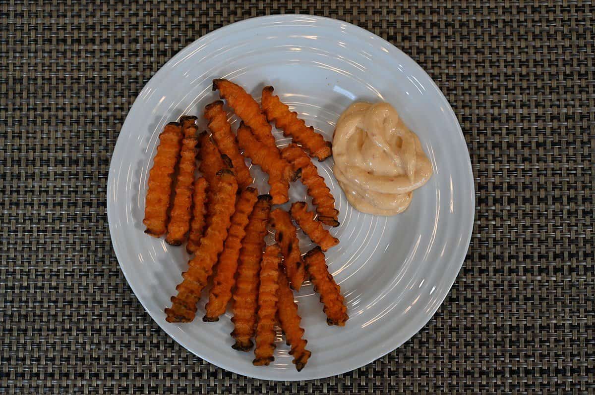 Culinary Treasures Jalapeno Lime Aioli served on a plate beside sweet potato fries. 