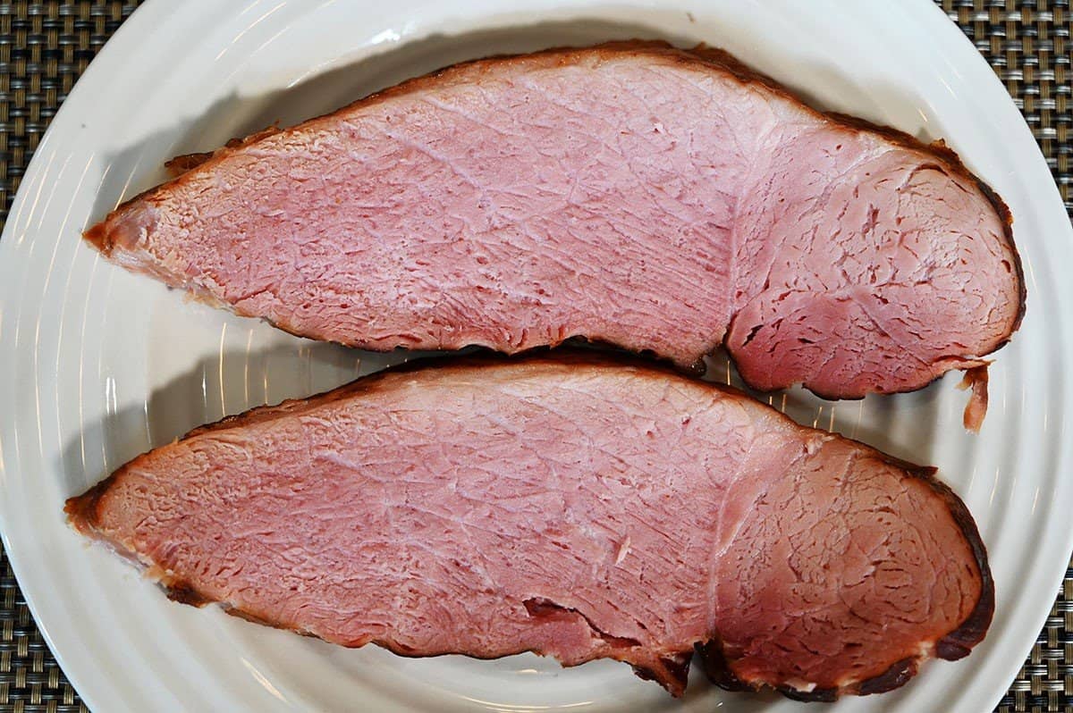 Slices of Costco Kirkland Signature Master Carve Ham served on a white plate. 