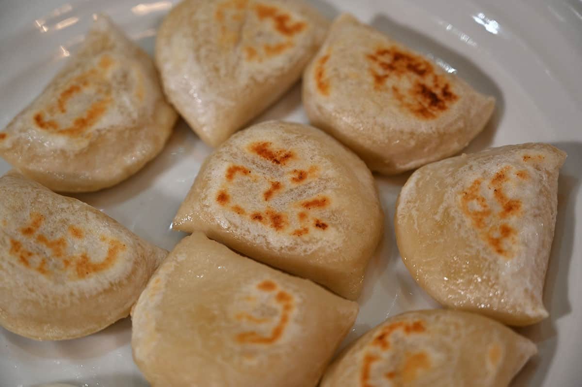 Closeup image of a plate of cooked Costco Naleway Potato and White Cheddar Perogies. 