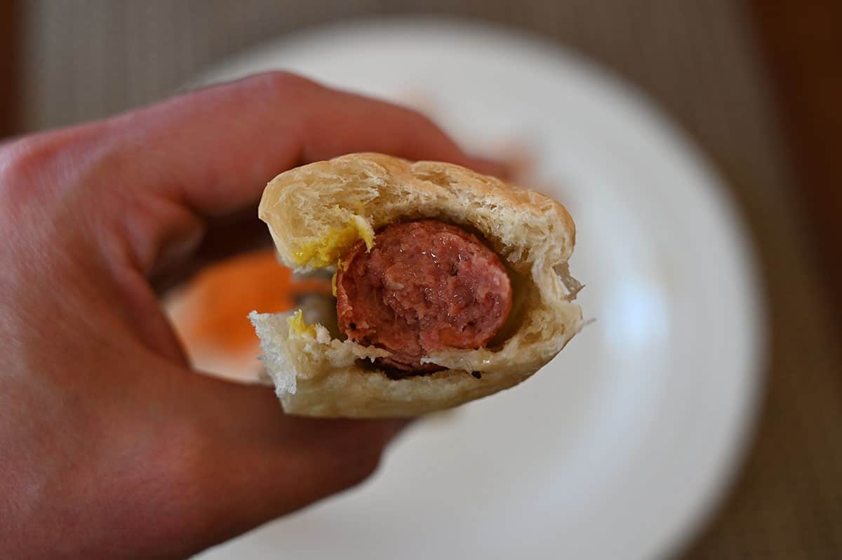 Costco Kirkland Signature Beef Polish Sausage in a bun, closeup image of a bite taken out of it. 