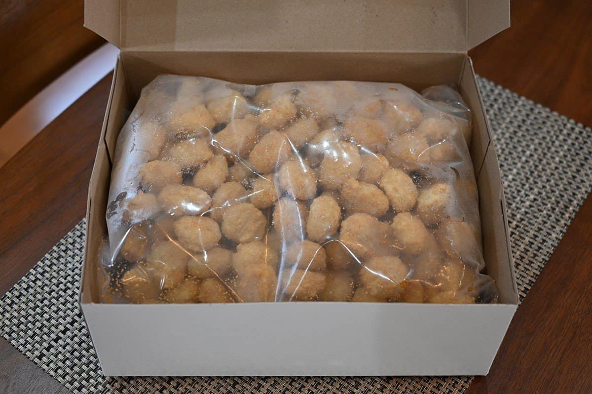 Image of the Hampton House Popcorn Chicken box opened so you can see the popcorn chicken frozen in a bag. 