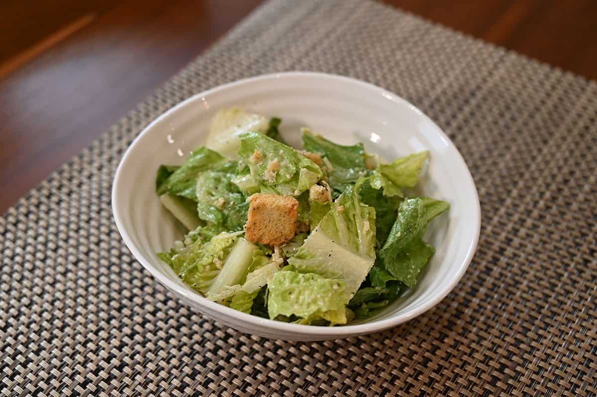 Costco Taylor Farms Ultimate Caesar Salad Kit prepared and served in a white bowl. 