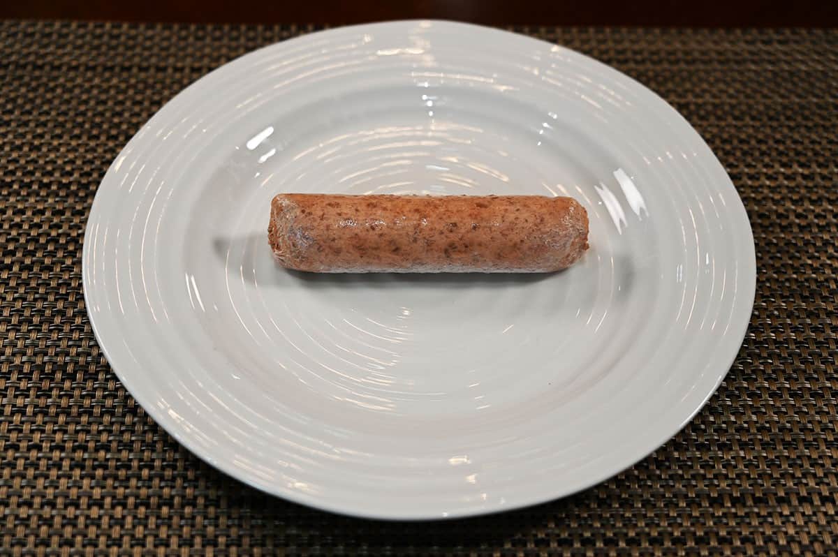 Image of one frozen Beyond Sausage sitting on a white plate. 