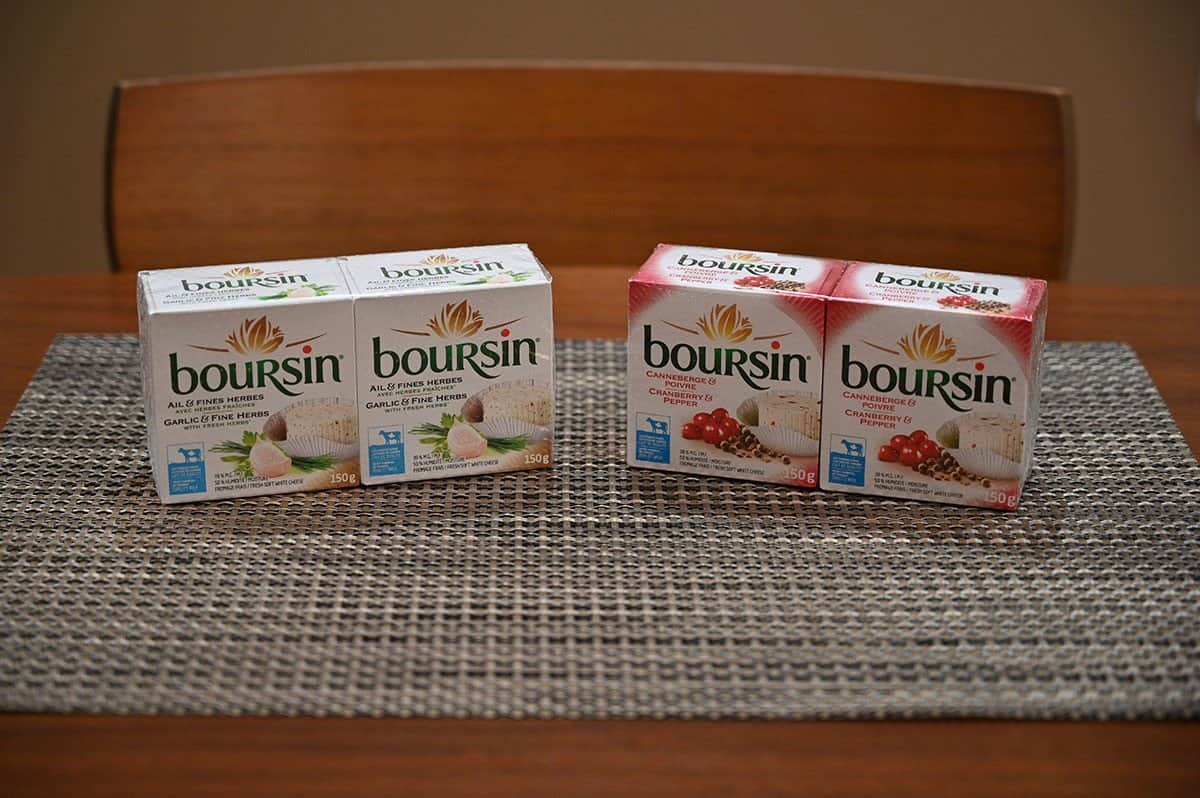 Image showing both Costco Boursin Cheese flavors, garlic & fine herbs and cranberry & black pepper sitting on a table. 
