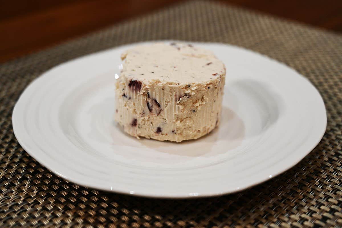Image of unwrapped cranberry & pepper flavor Boursin cheese on a white plate. 