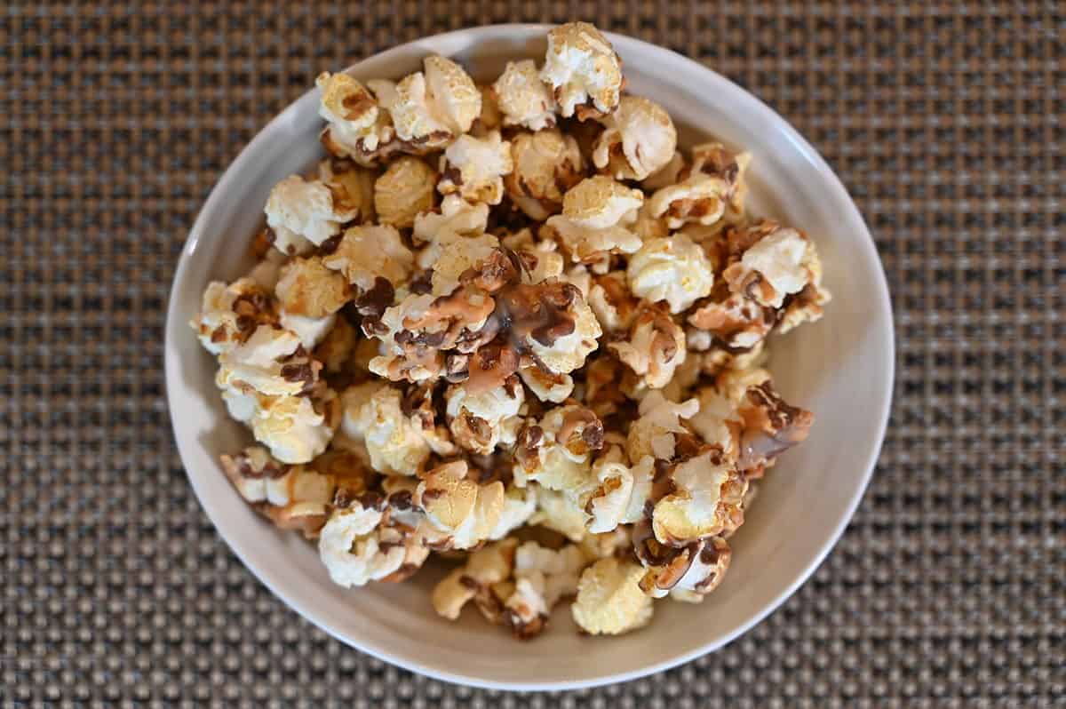 Costco Snickers Candy Pop Popcorn poured into a white bowl. Top down image. 