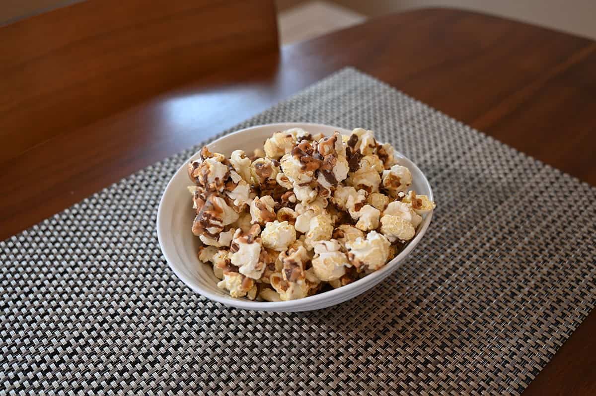 Costco Snickers Candy Pop Popcorn poured into a white bowl. Side image. 