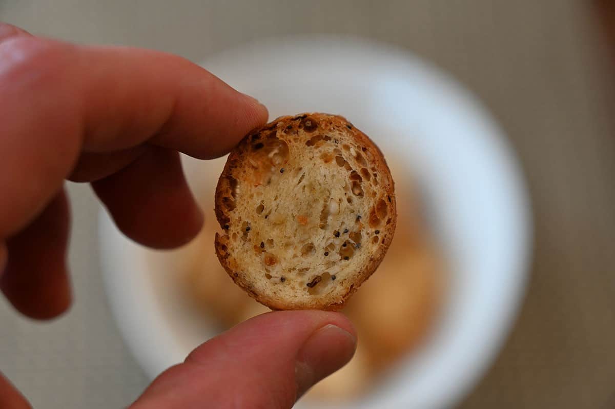 Closeup image of one Costco Schwartz Brothers Everything Bagel Chip being held. 