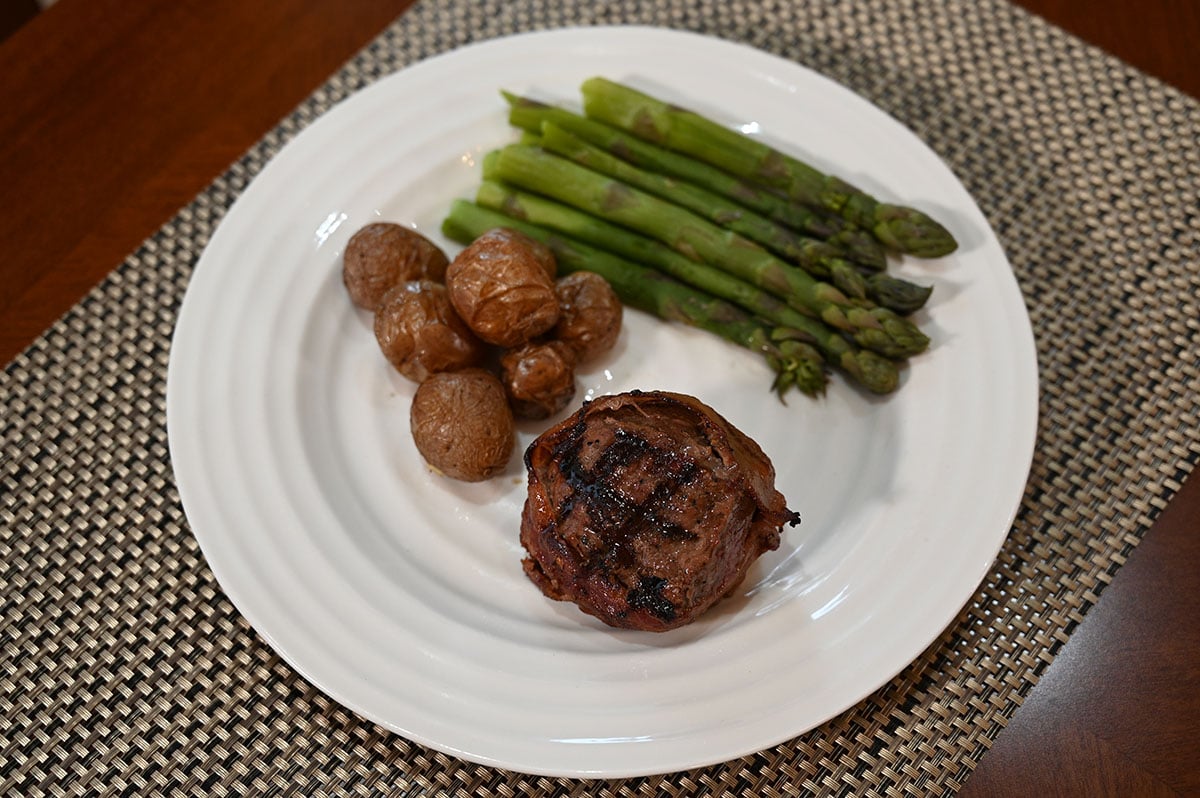 Picture of a plate with beef tournedo, potatos and asparagus. 