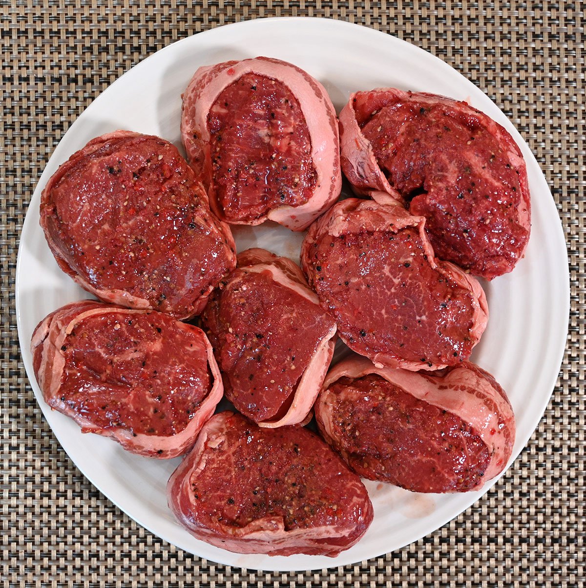 Image of a plate of raw beef tournedos from Costco ready to be cooked. 