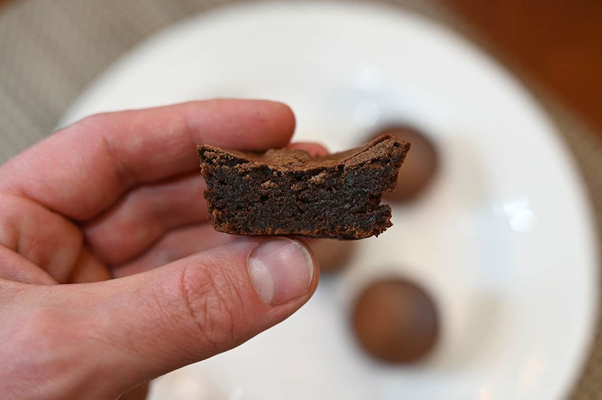 Close up image of one Costco Charlotte's Mini Chocolate Brownie with a bite taken out so the center is visible.