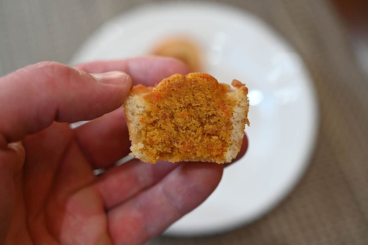 Closeup image of one Costco Sugar Bowl Bakery Carrot Cake Bite with a bite taken out to show the center.