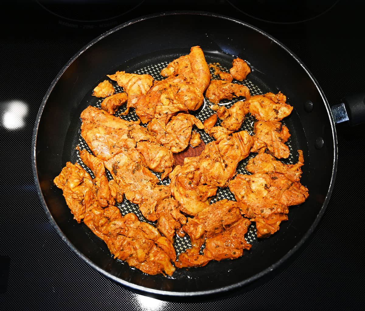 Image of the tandoori chicken being cooked in a frying pan.
