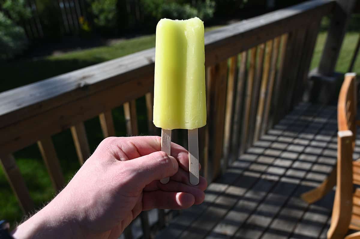 Image of the banana popsicle, outside on a deck in a backyard.