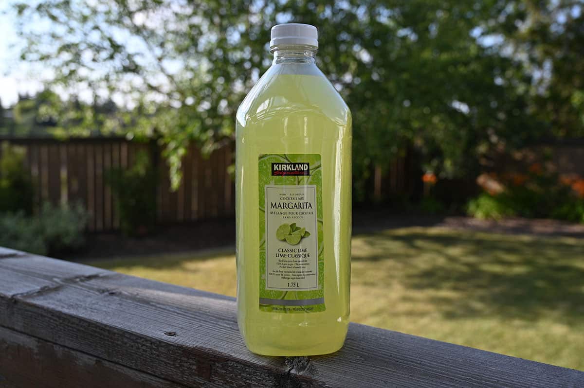 Image of the old Costco Kirkland Signature Margarita Mix bottle sitting on a deck outside.