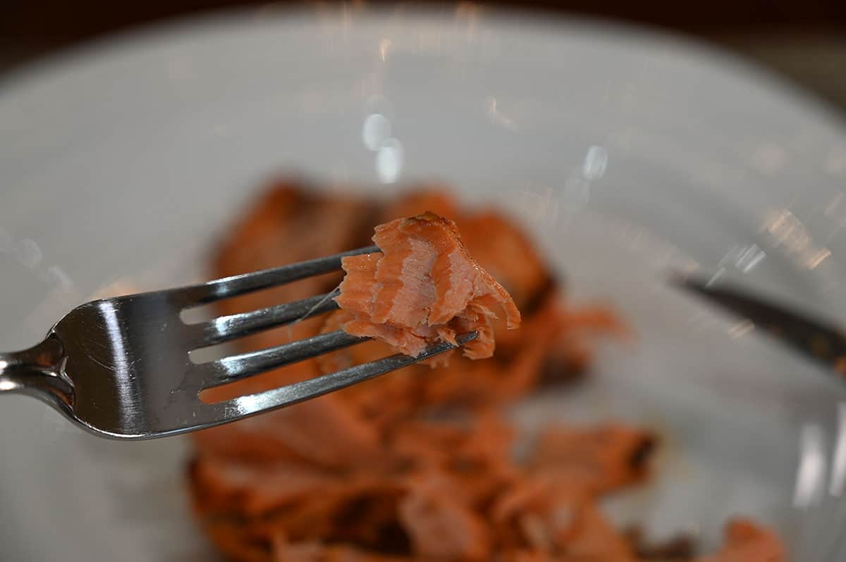 Closeup image of a forkful of salmon showing the texture.