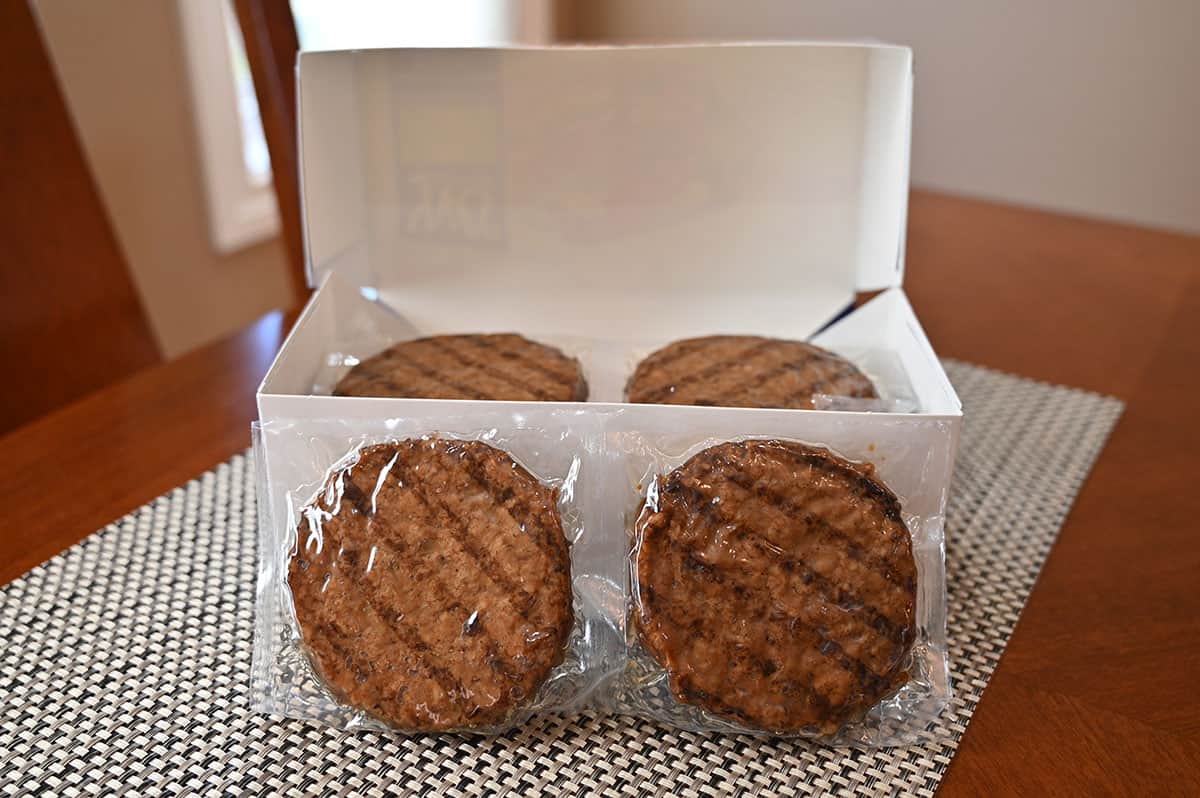 Image of the box of veggie burgers open with a pack of two veggie burgers in plastic in front of the box.