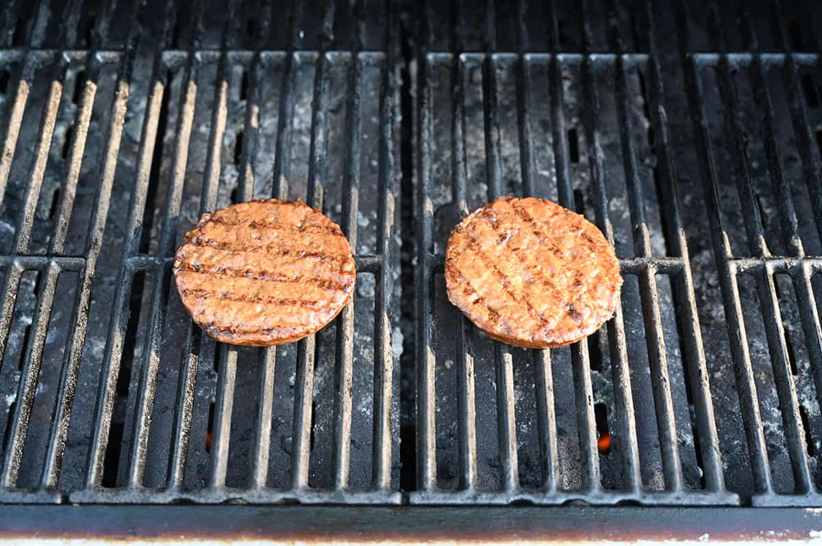 Image of two veggie burgers being grilled on the barbecue.