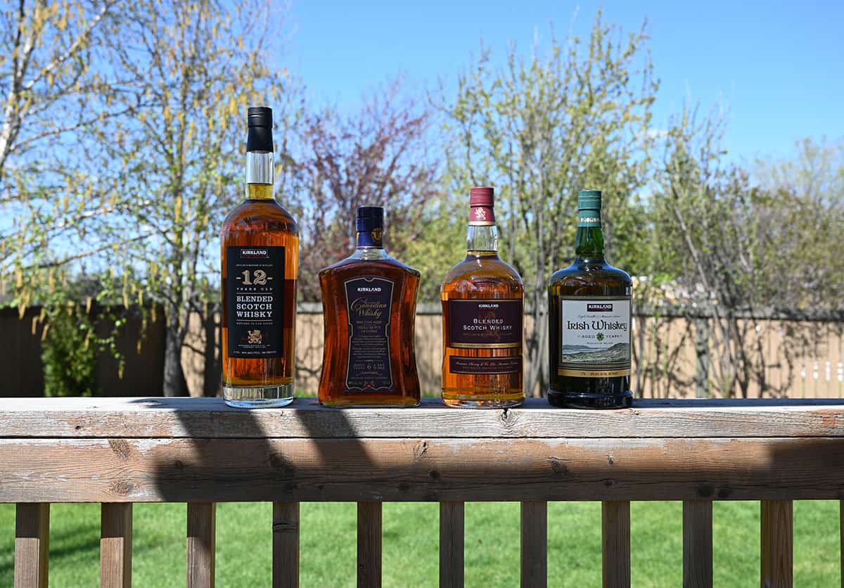 Four bottles of different Kirkland Signature whiskeys lined up.