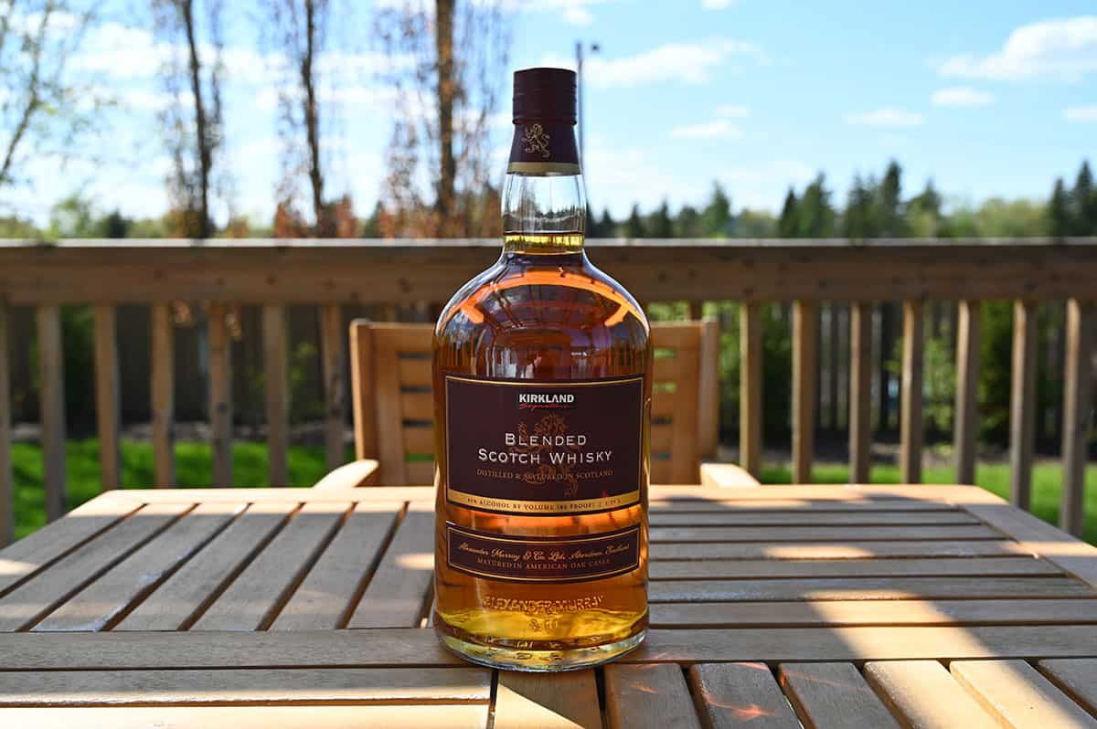 Image of the bottle of Kirkland Signature Blended Scotch Whisky sitting on a table outside.