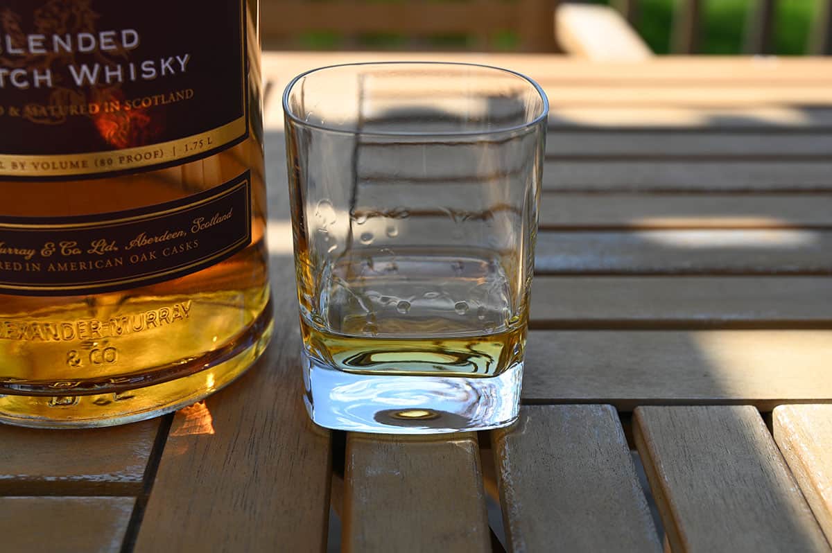 Image of a glass of the Costco Blended Scotch Whisky on a table outside.