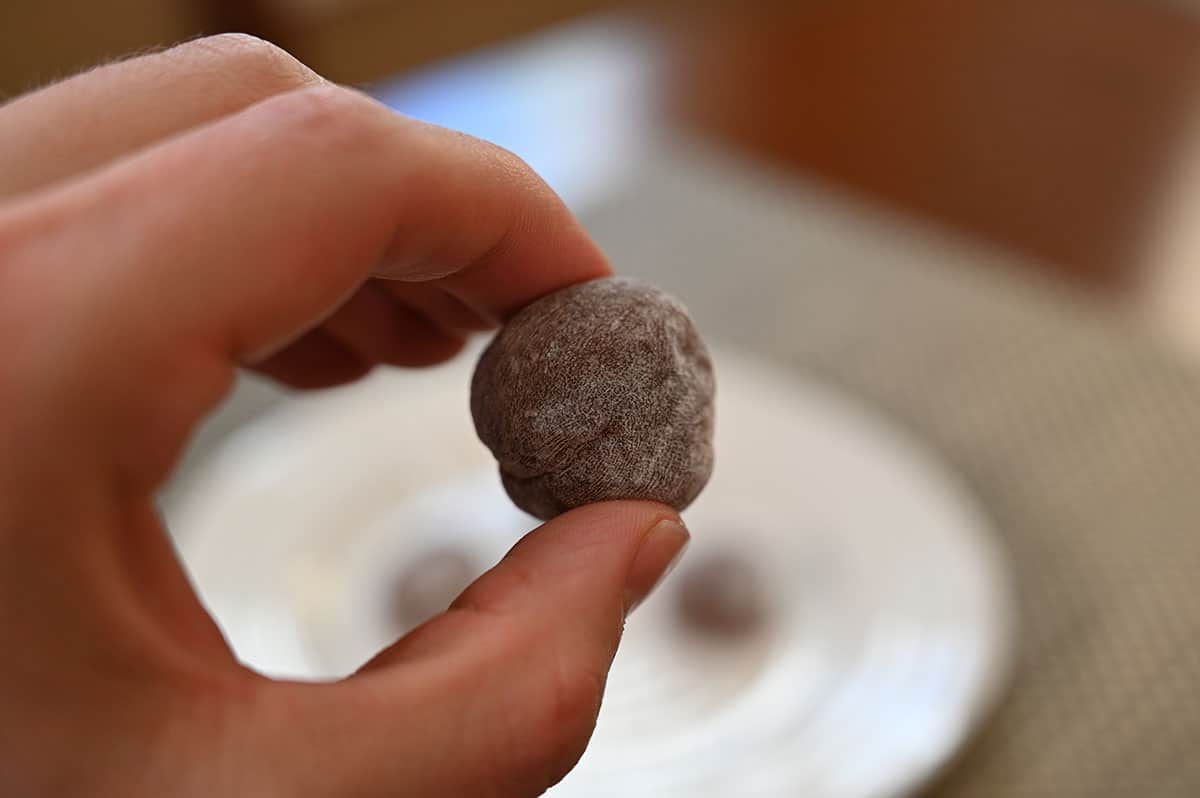Closeup image of a hand holding one mochi. 