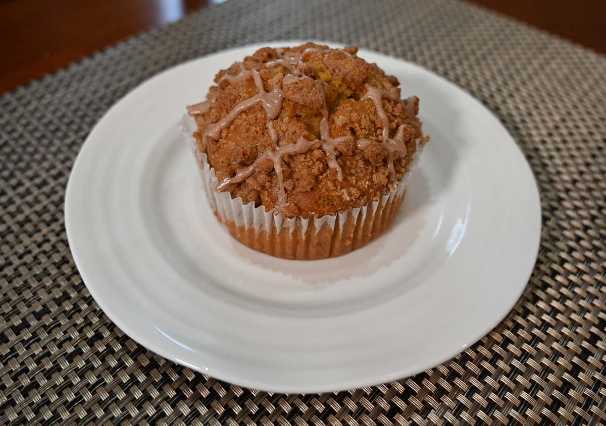 Image of one apple crumb muffin on a plate.