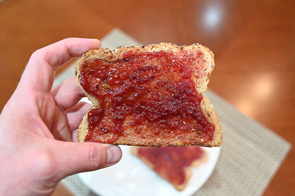 Closeup image of one piece of toast with raspberry jam on it.