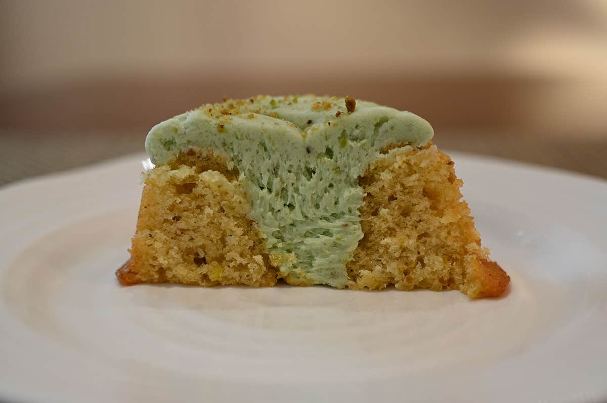 Side view of a mini bundt cut in a half, so you can see all the icing in the middle and the inside of the cake.