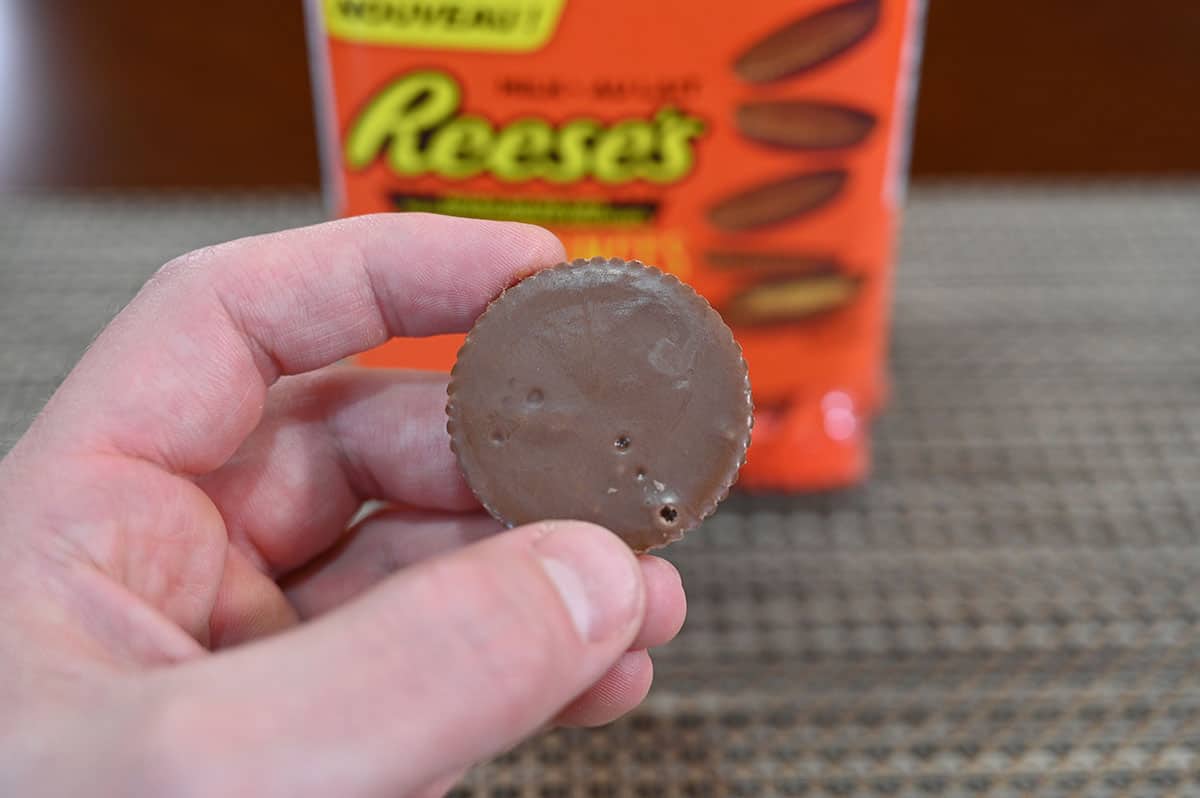 Image showing the top of one Reese's Thins Peanut Butter cups witht the container in the back.