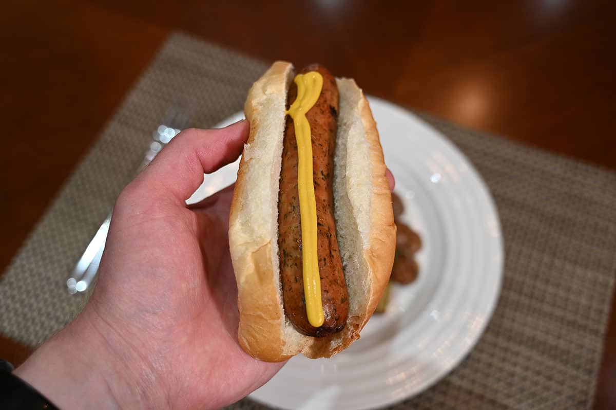 Close up image of the sausage in a bun with a single line of mustard down the middle.