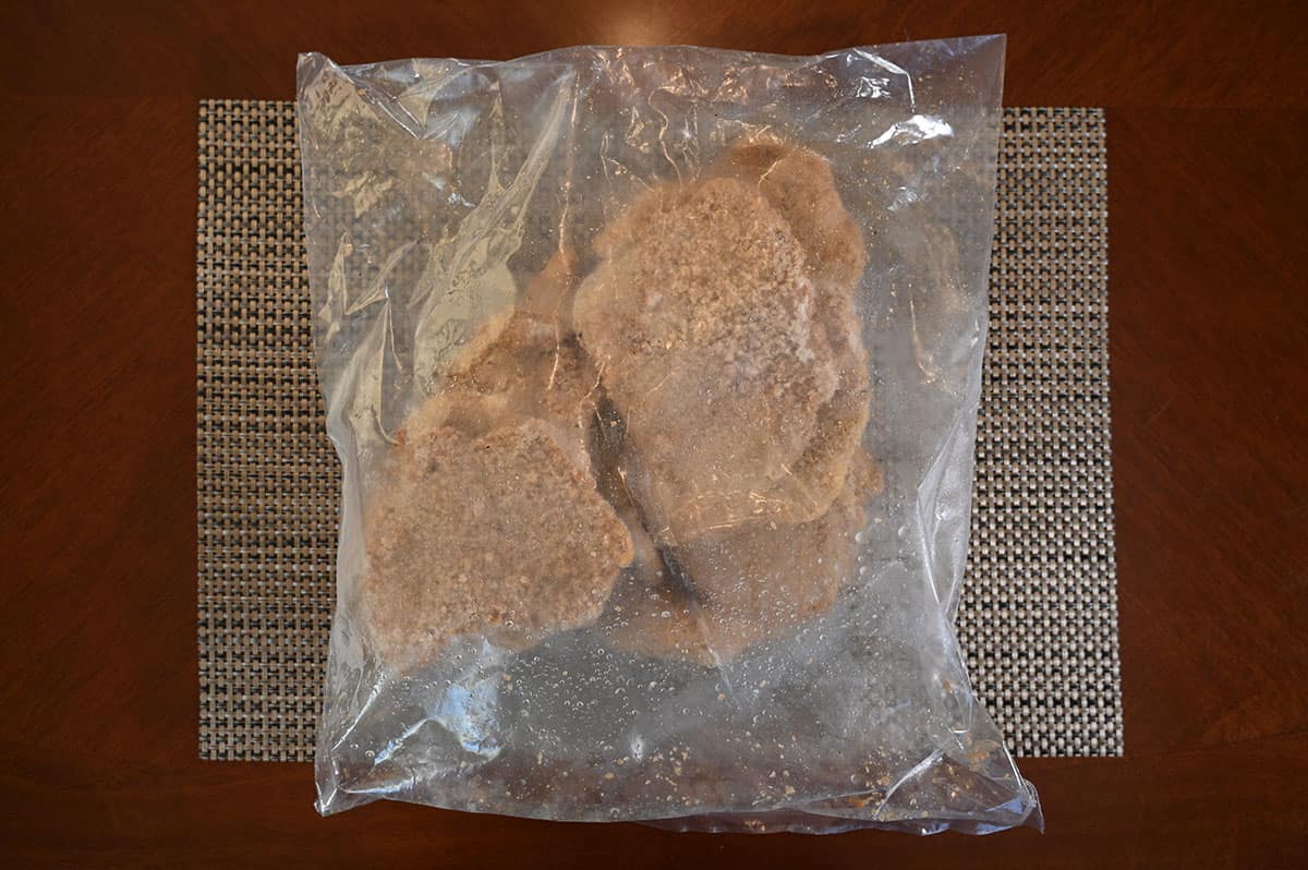 Image of the bag from the box containing frozen pieces of pork schnitzel. 