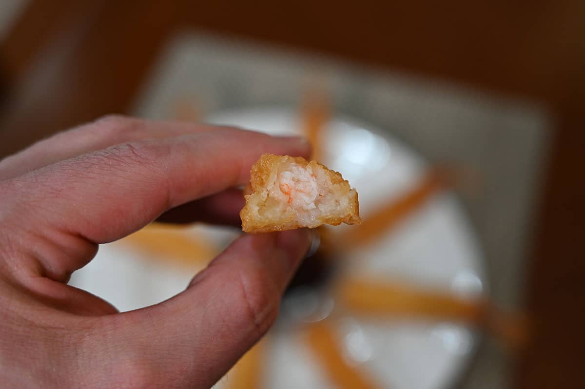 Image of a tempura shrimp with a bite taken out of it so you can see the center.