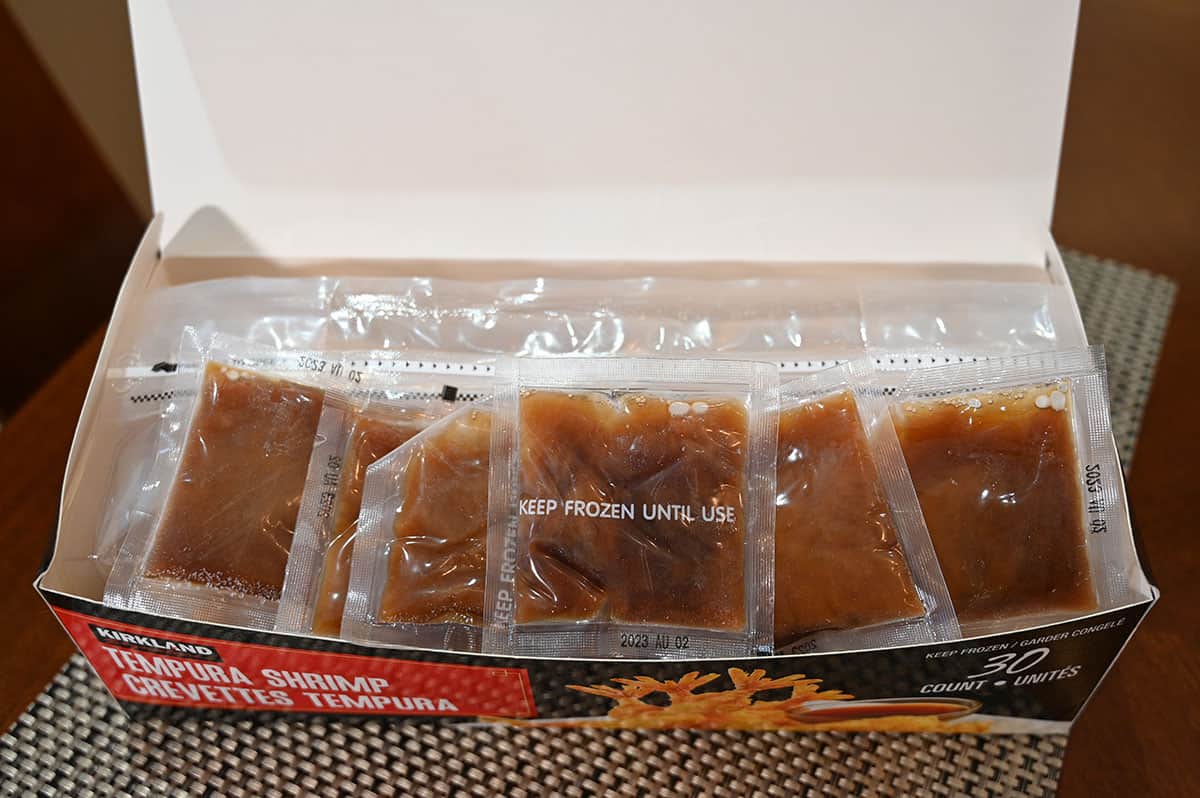 Image of the box of tempura shrimp open, showing six sauce packets in it.