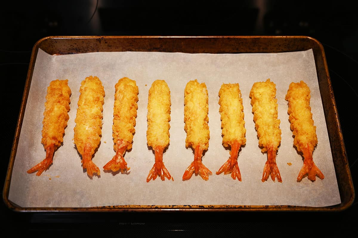 Image of the a cookie sheet with tempura shrimp on it being baked in the oven.