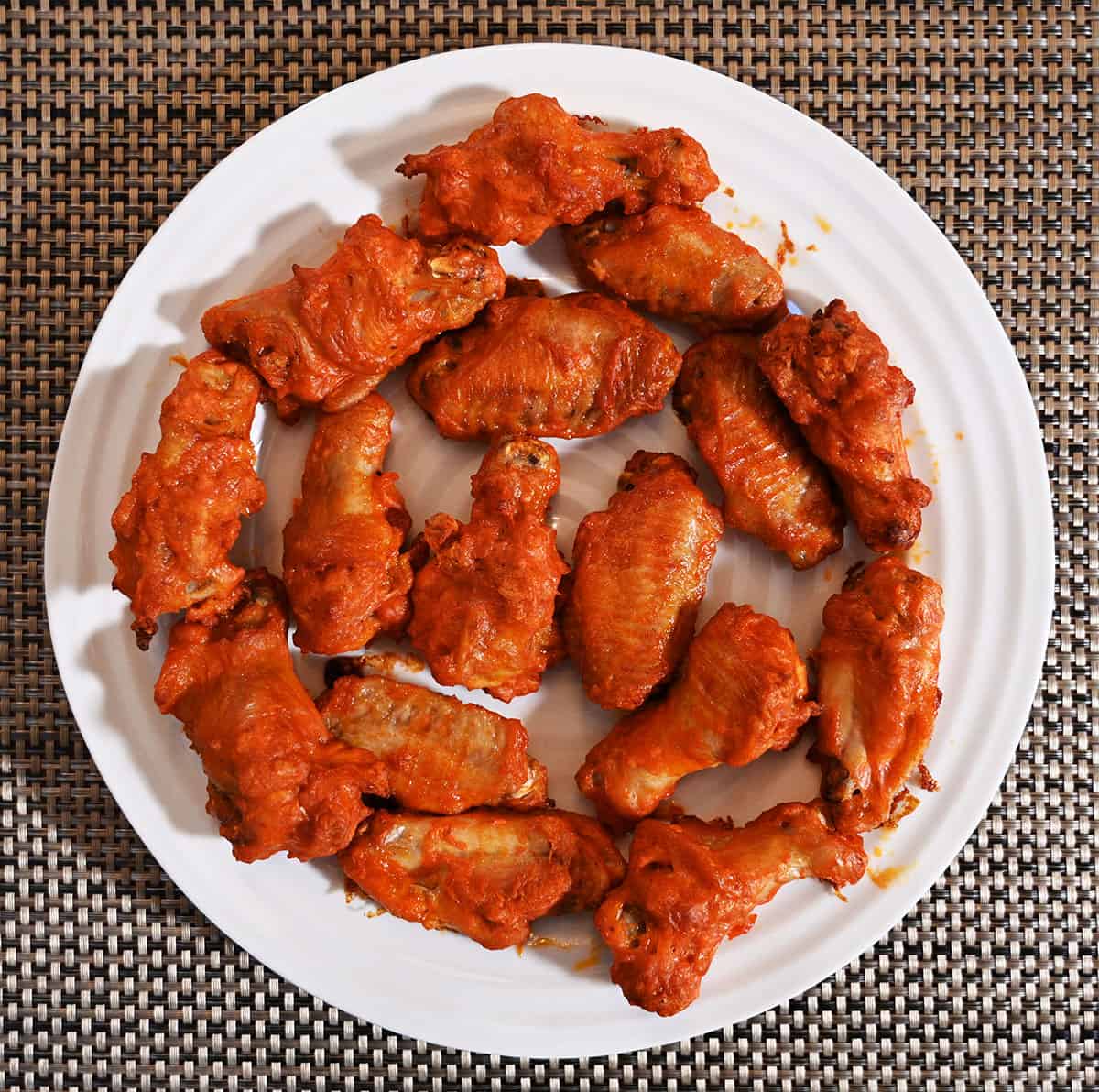 A white plate with cooked chicken wings. Top down image.