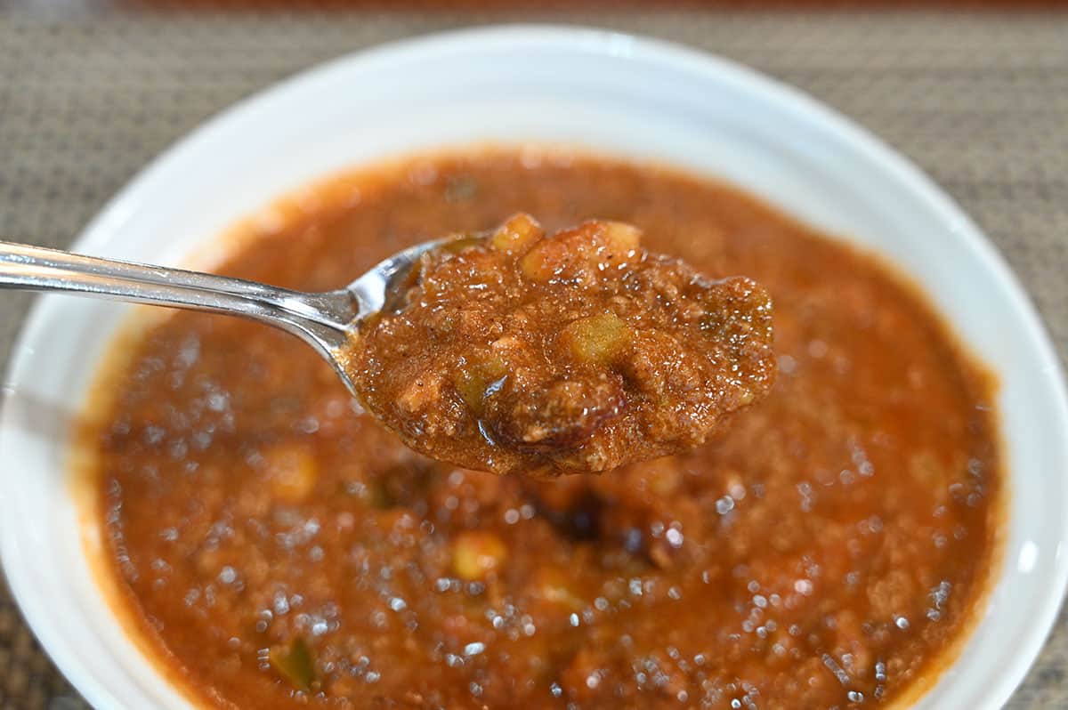 Closeup image of a spoonful of chili with a bowl of chili in the background.