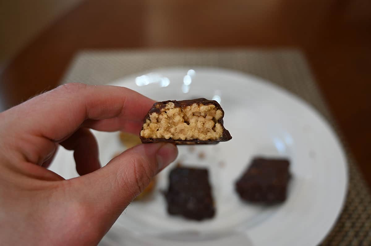 Close up image of the caramel almond protein bar with a bite taken out so you can see the crispy texture middle.