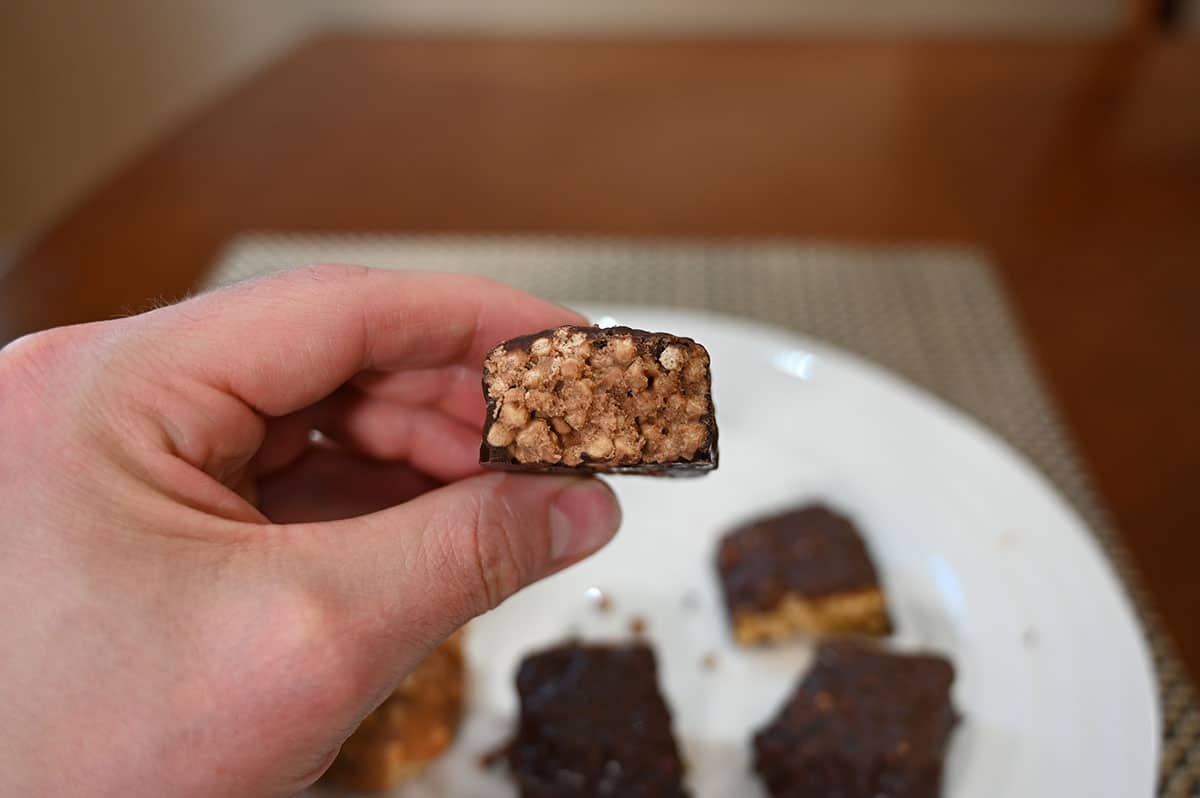 Close up image of the choco crisp protein bar with a bite taken out so you can see the crispy texture middle.