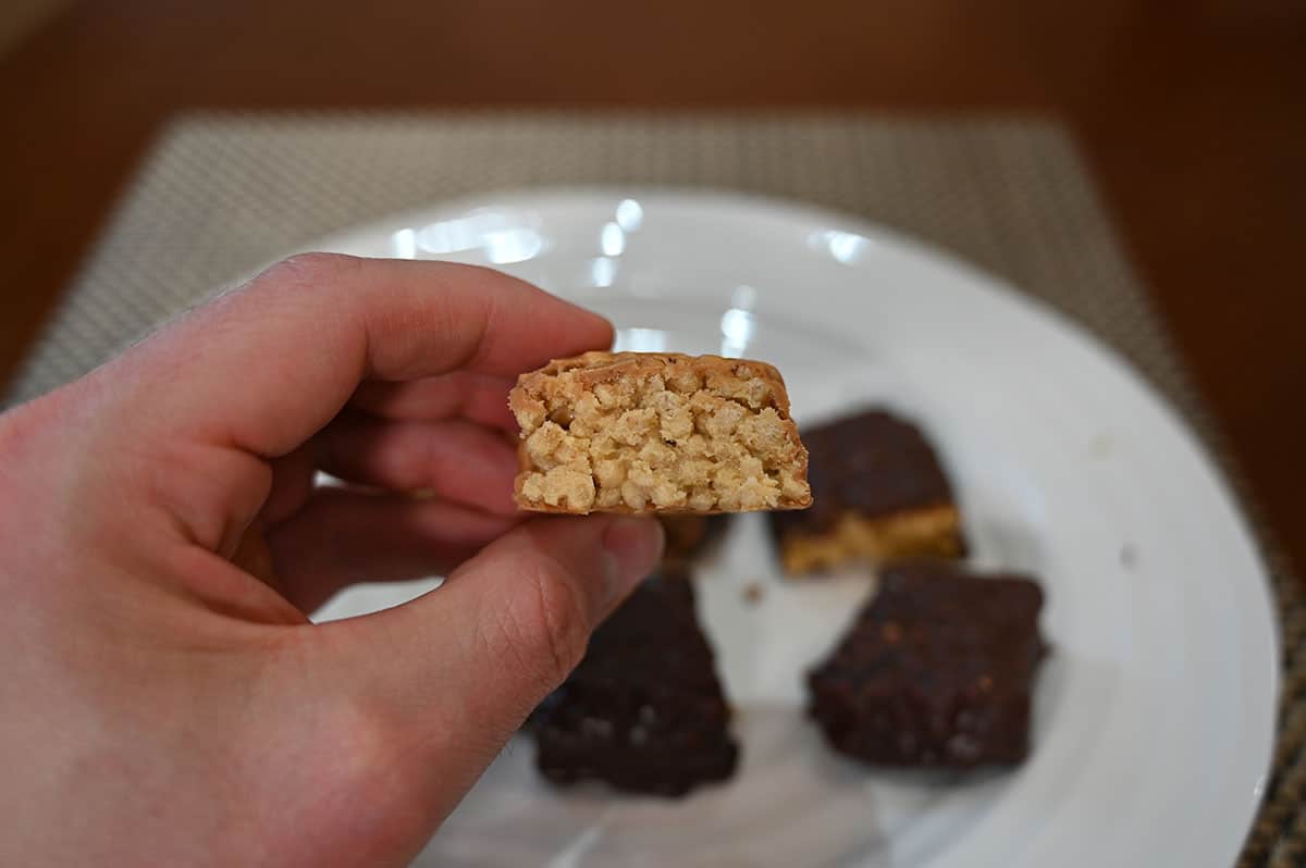 Close up image of the peanut butter protein bar with a bite taken out so you can see the crispy texture middle.