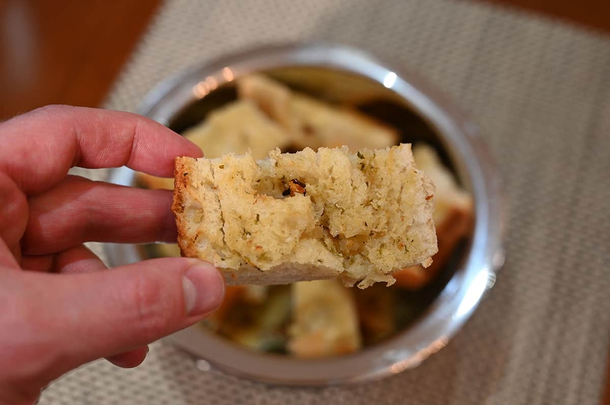 Closeup image of one baked and cut piece of garlic bread.