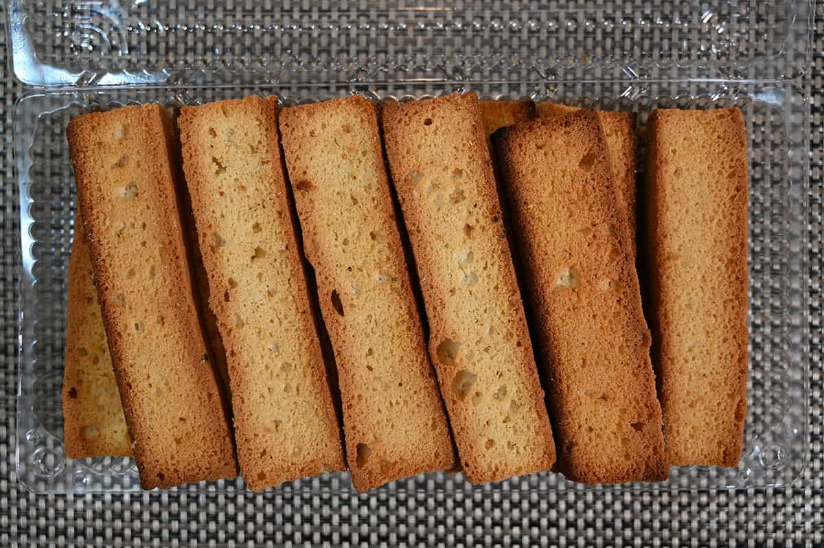 Image of the cake rusks in their plastic container with the lid off, top down image.
