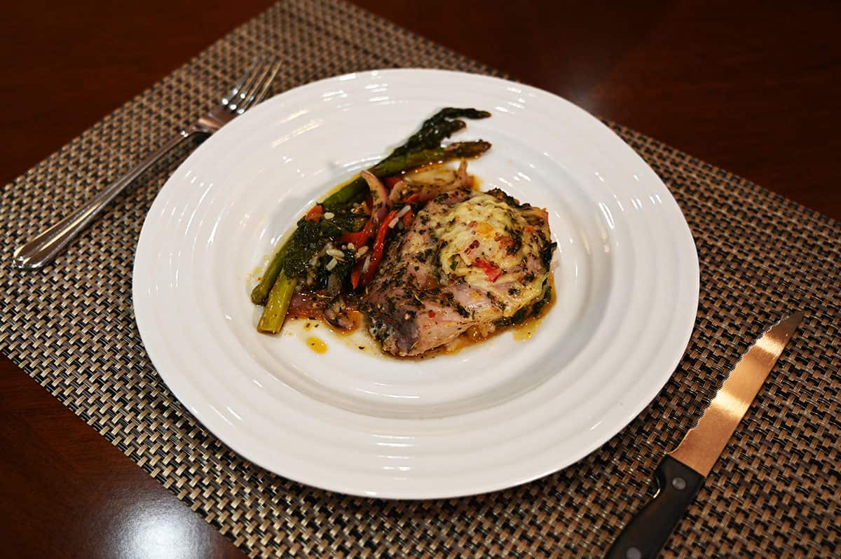 Image of the pork tenderloin served on a white plate with asparagus beside it.