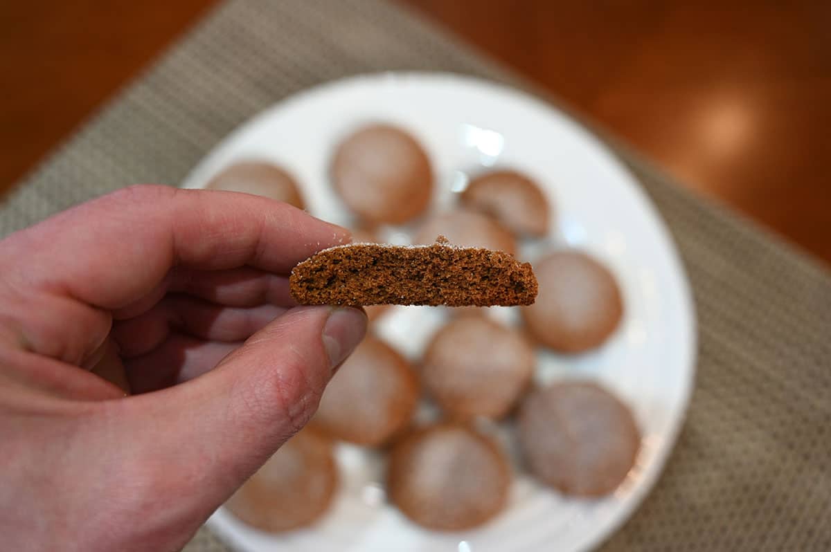 Closeup image of a hand holding a cookie with a bite taken out so you can see the texture of the middle of the cookie.