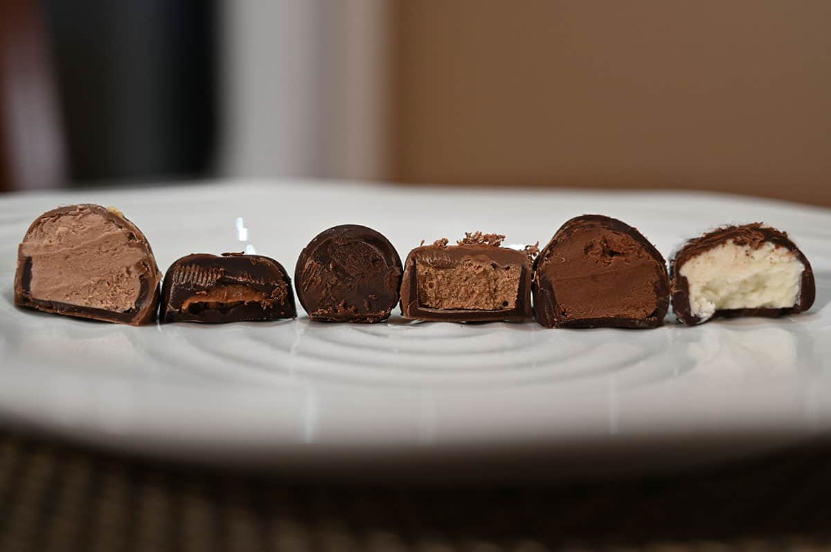 Closeup image of six of the chocolates cut in half on a white plate showing the center of them.