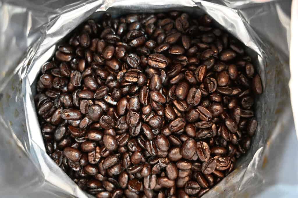 Top down image of the Starbucks French Roast Coffee Beans bag opened so you can see the coffee beans.